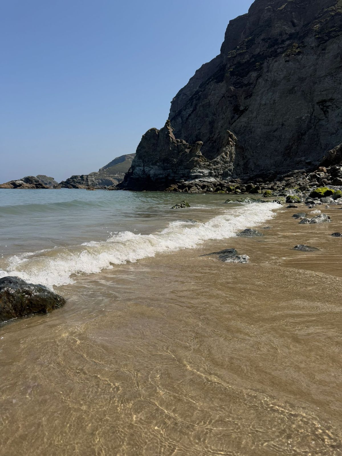 Turquoise water washing onto a Cornish beach
