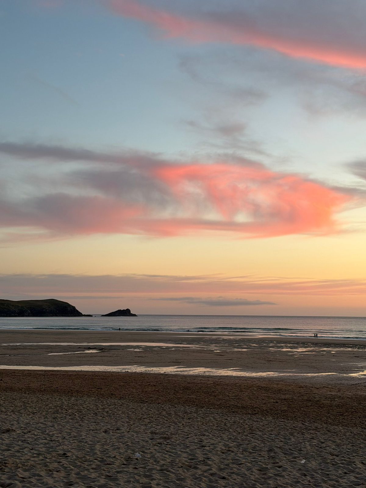 Pink sunset clouds over a wide Cornish beach